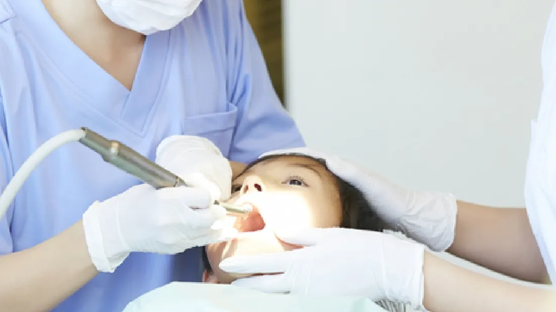 患者の口の中に器具を入れ治療する様子