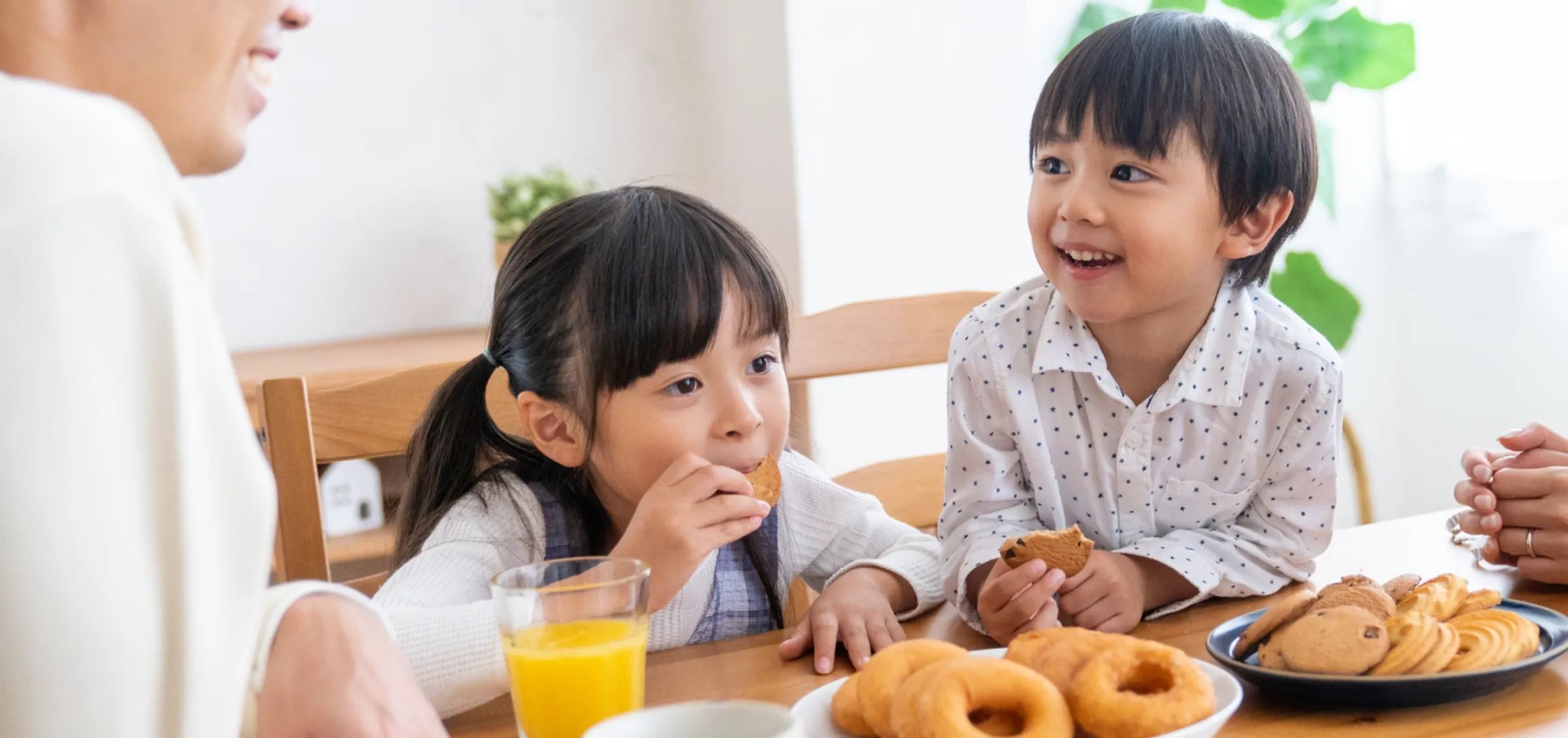 ドーナツやクッキーを食べる子どもたち