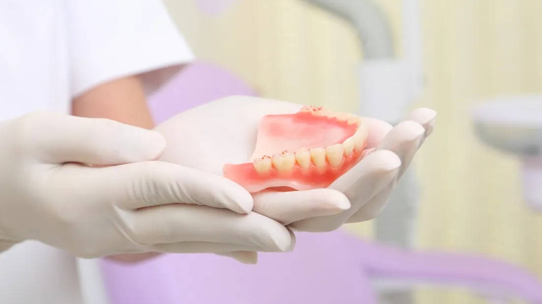 両手で入れ歯を持つ様子